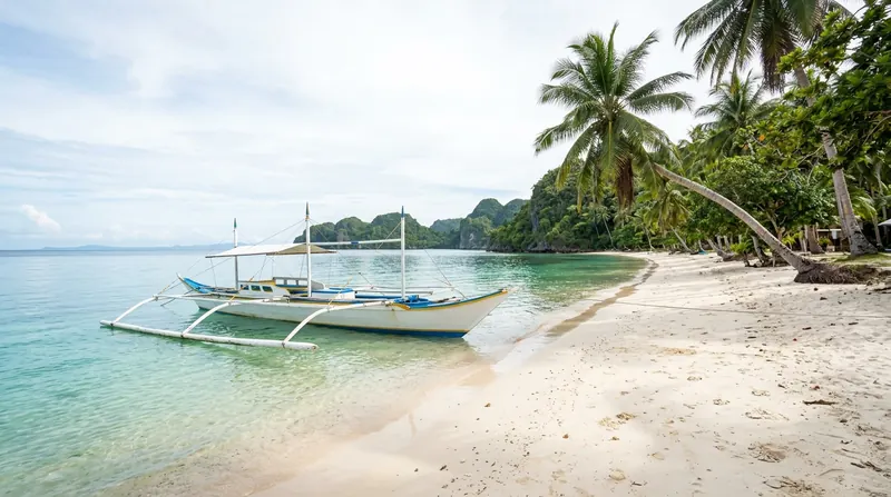Weißer Sandstrand mit Palmen und einem traditionellen Auslegerboot auf Cebu
